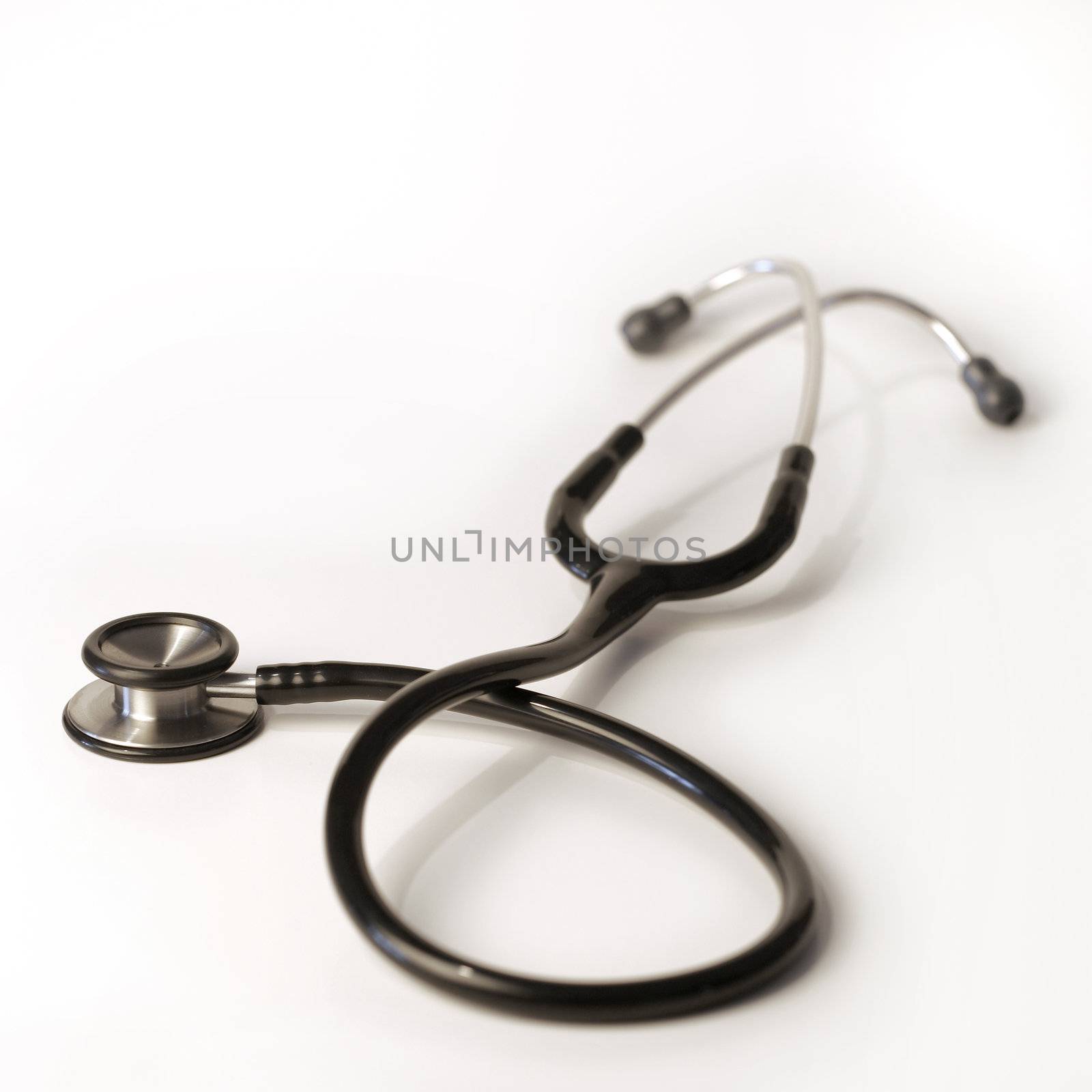 A shallow depth-of-field image of a stethoscope on white background.
