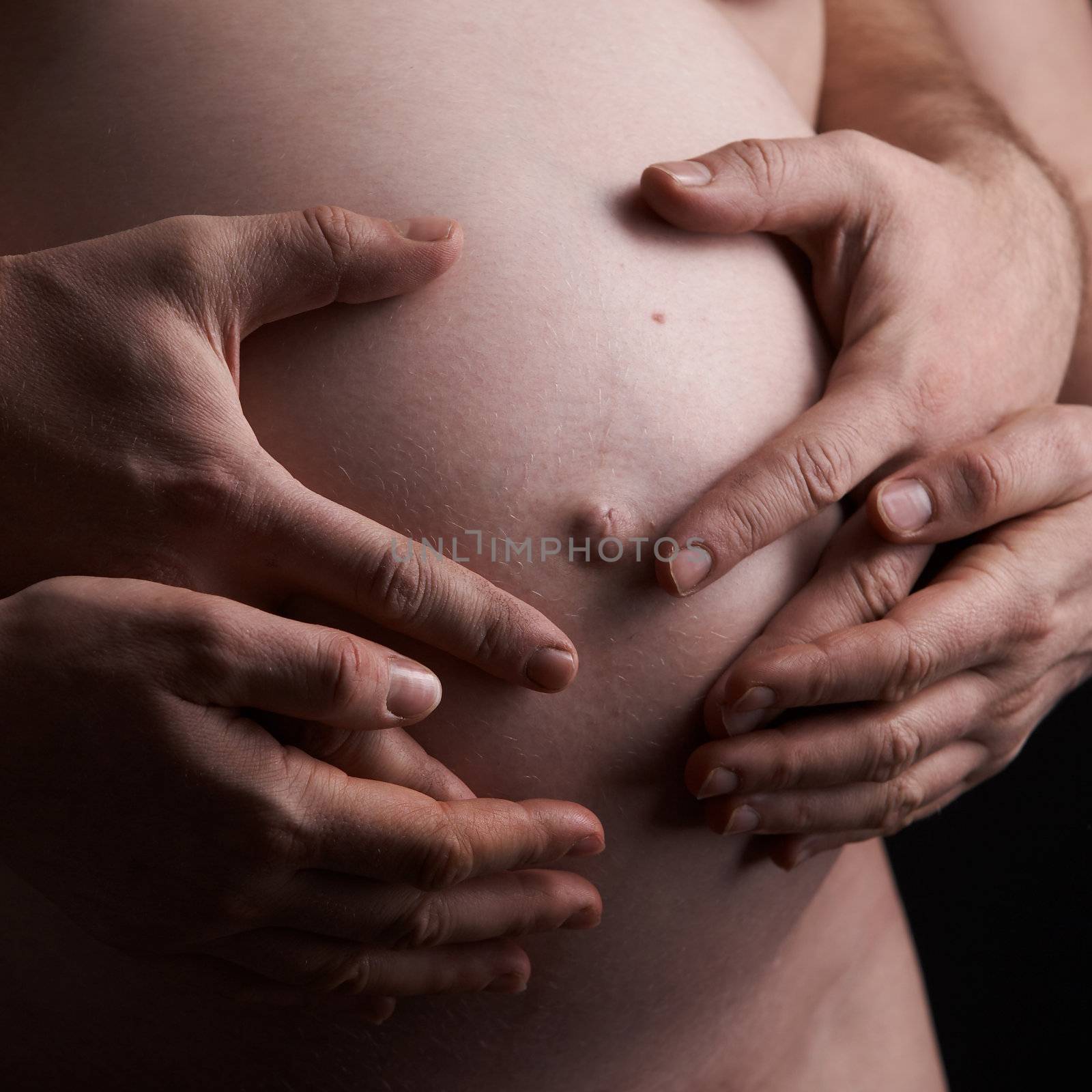 macro picture of woman`s and man`s  hands on the future baby