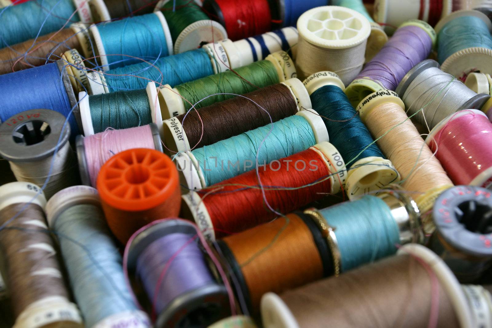 Colourful background assortment of bobbins and spools of thread. Shallow depth of field - focus in the middle.
