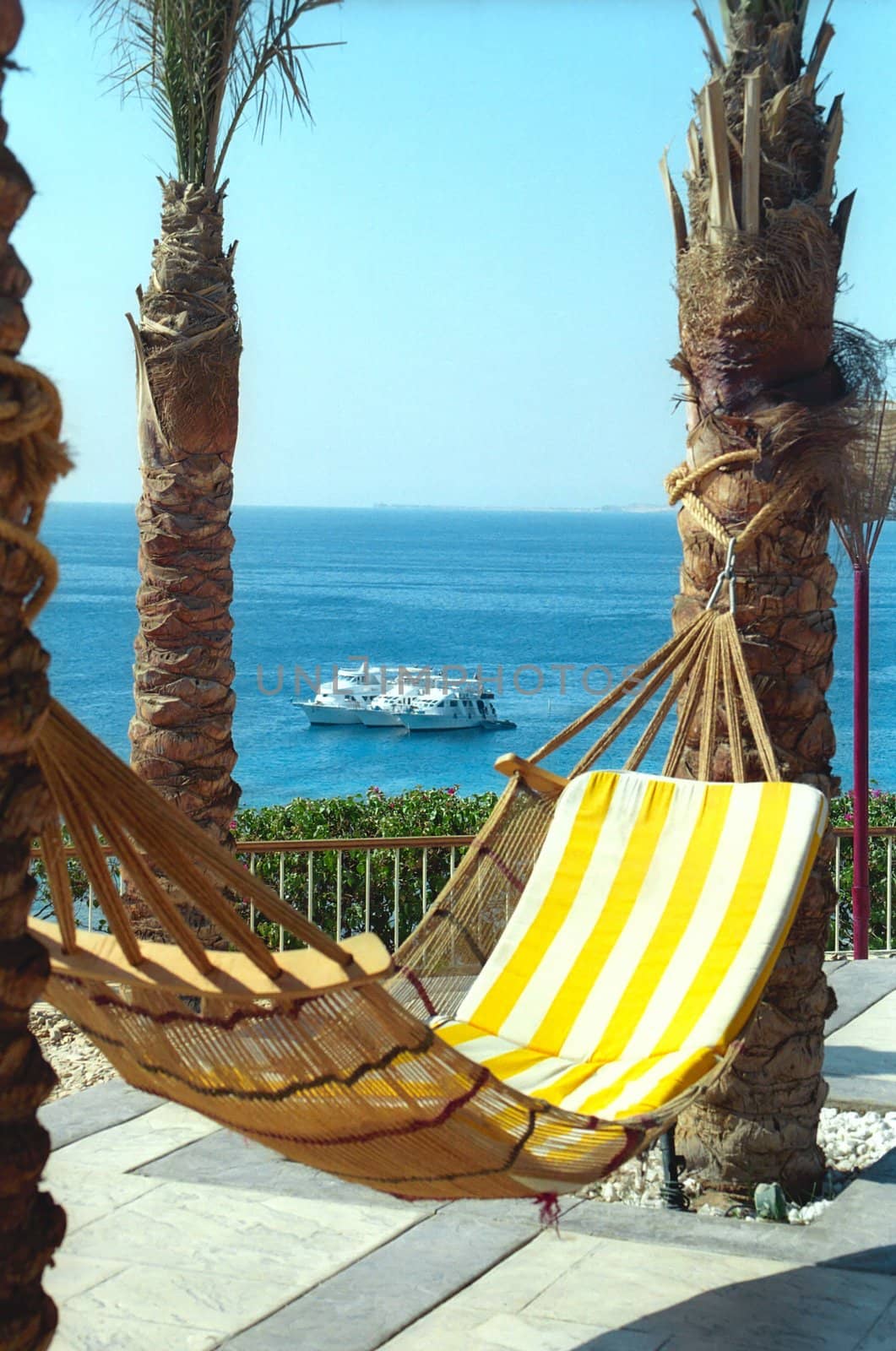 A hammock with the striped mattress is against the Sea and three cruisers