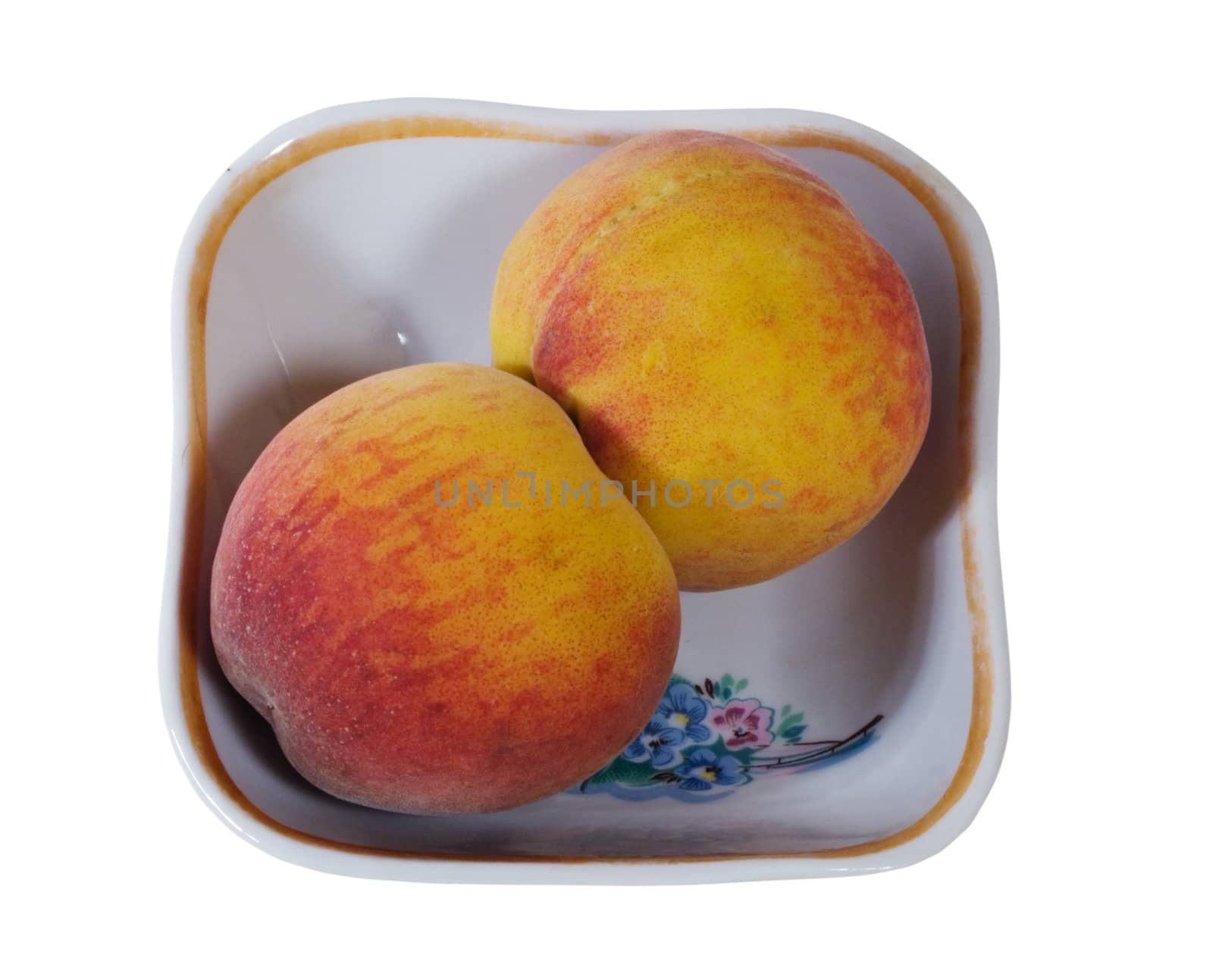 two peaches in the saucer. isolated on white.