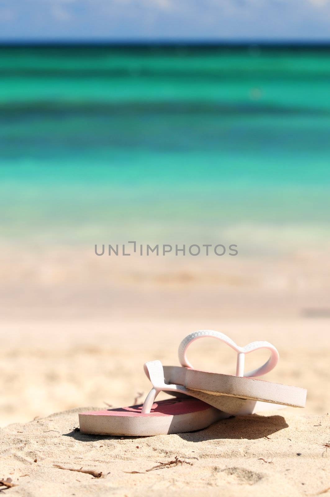 Flipflops on a sandy ocean beach - vacation concept