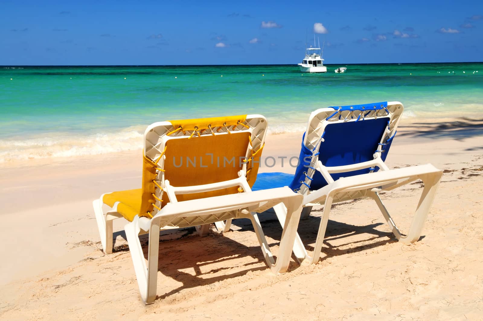 Two vacation chairs on sandy tropical beach of Caribbean island