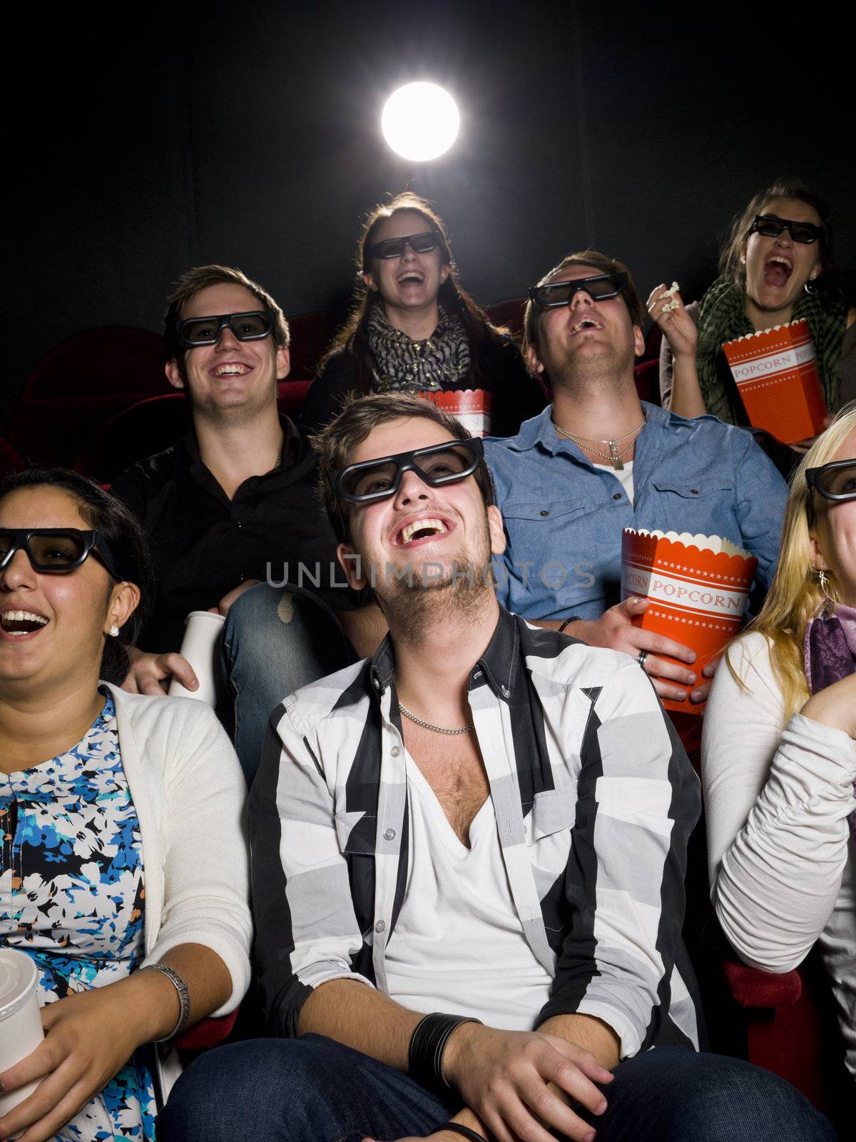 Happy people at the movie theater wearing 3d glasses