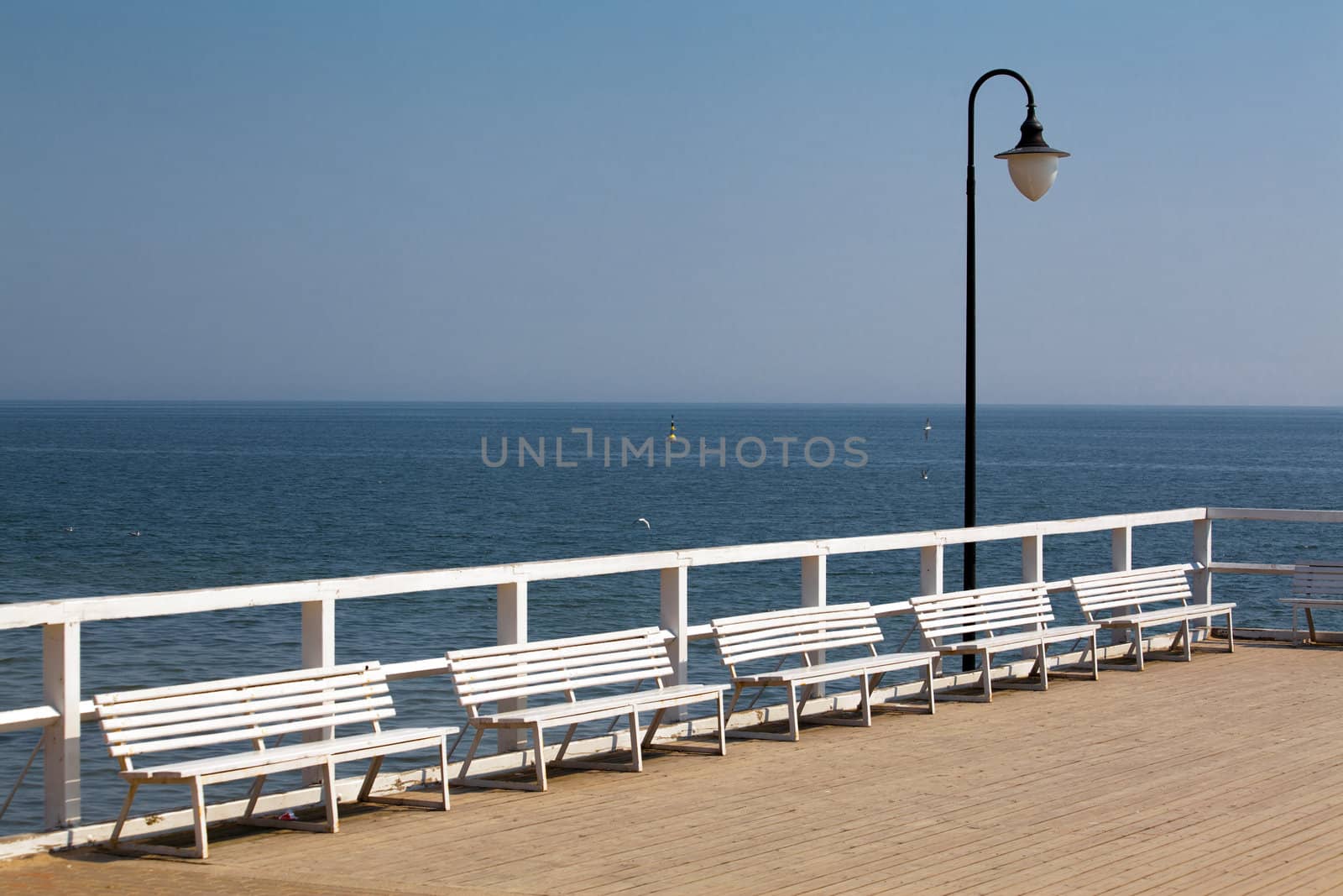 Wooden pier with white benches
