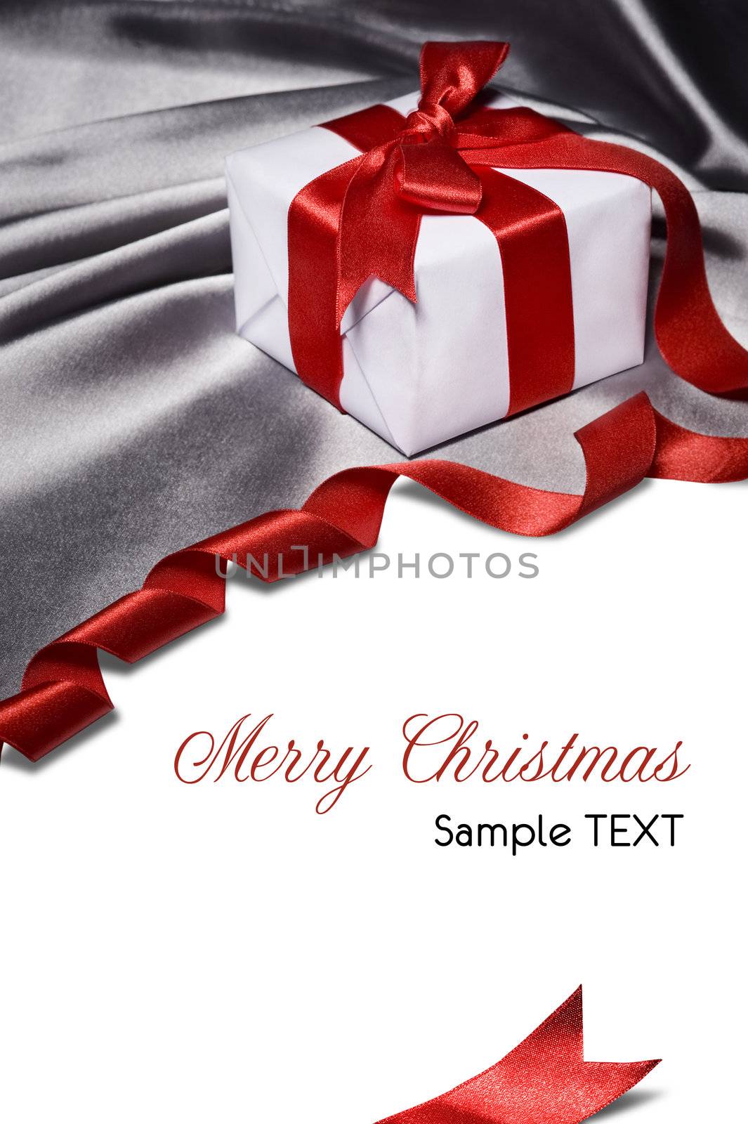 christmas gift with red ribbon, on silver satin material