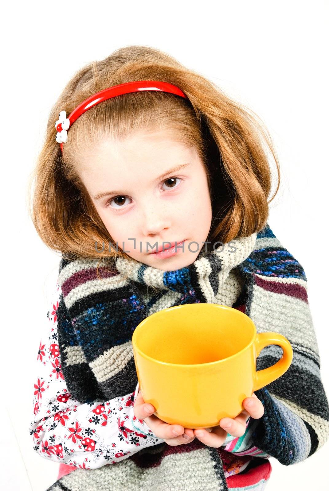 studio shot of pretty little girl with a cold holding a cup