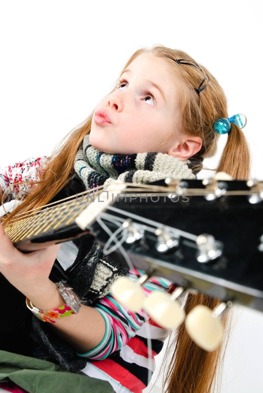 studio shot of pretty little girl playing black acoustic guitar