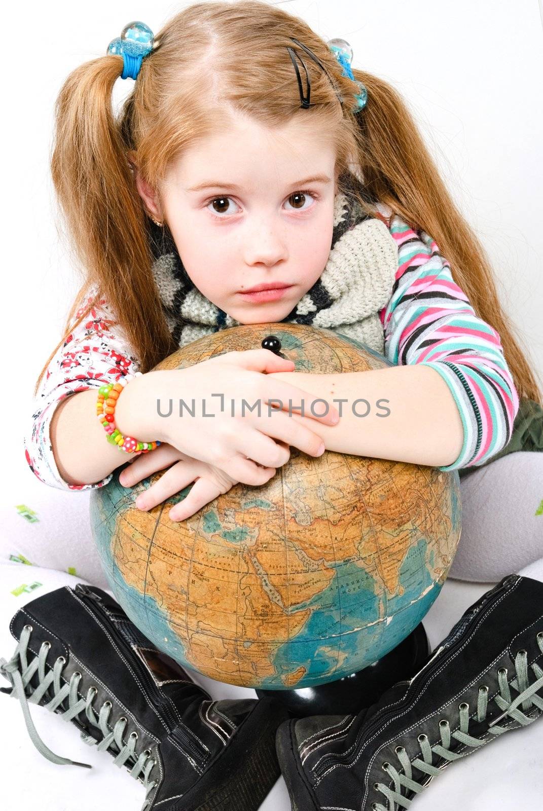 studio shot of pretty little girl holdibg an old globe