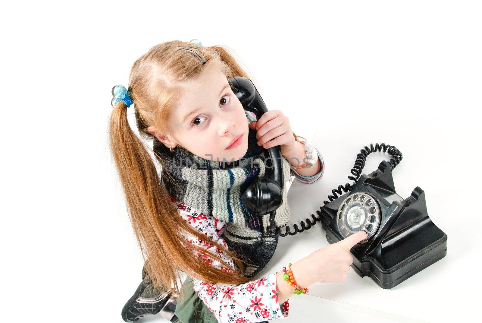 studio shot of pretty little girl calling the old phone