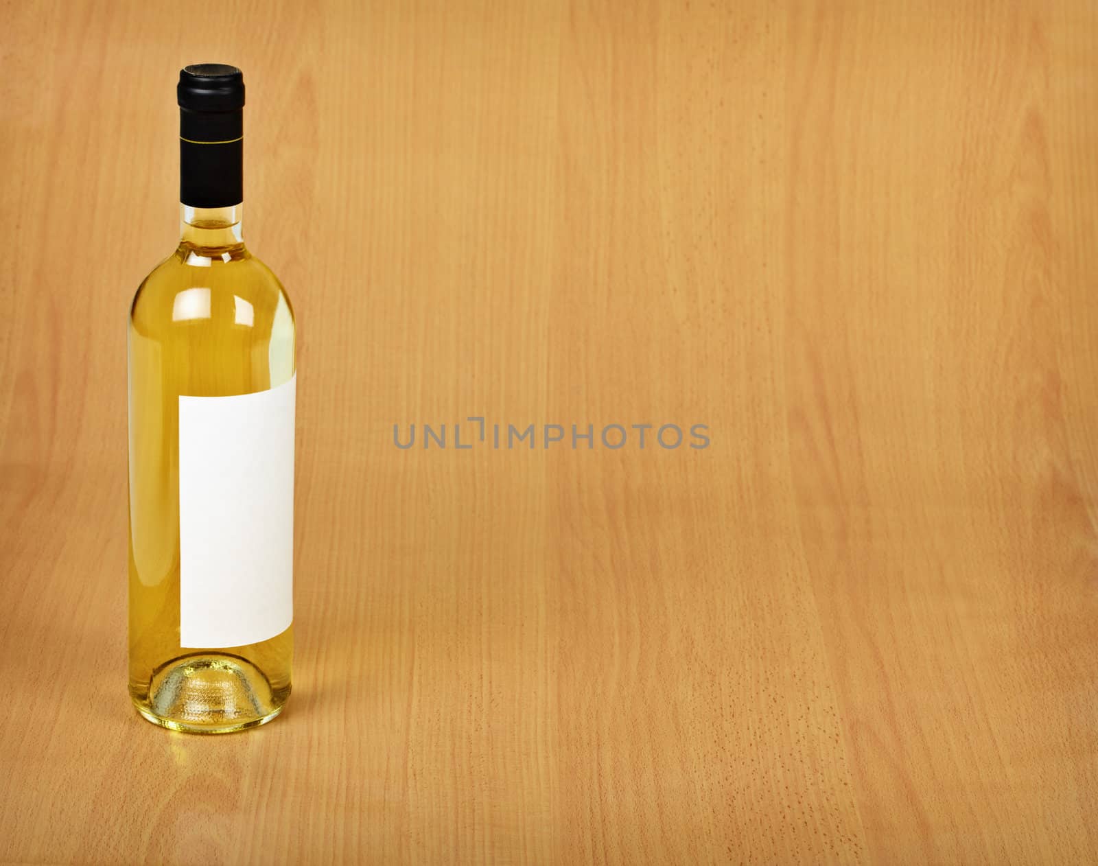 Bottle of white wine on wooden table by pzaxe