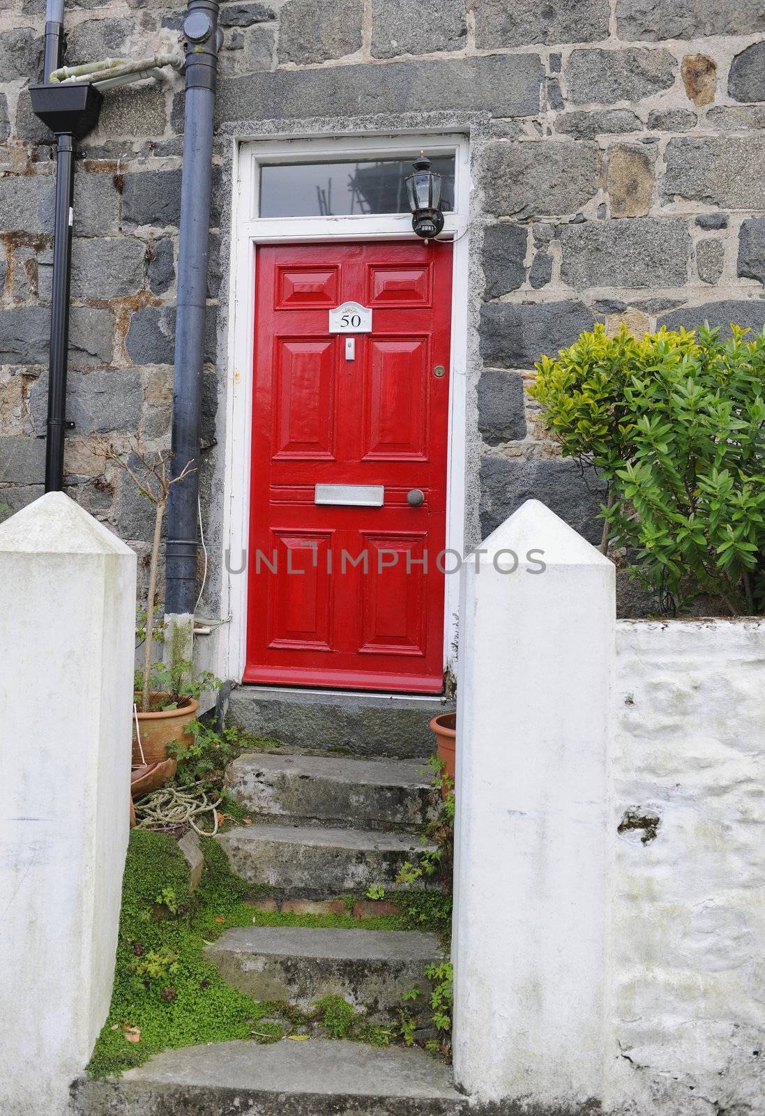 Red  door and ladder. A red door with ladder steps.Guernsey