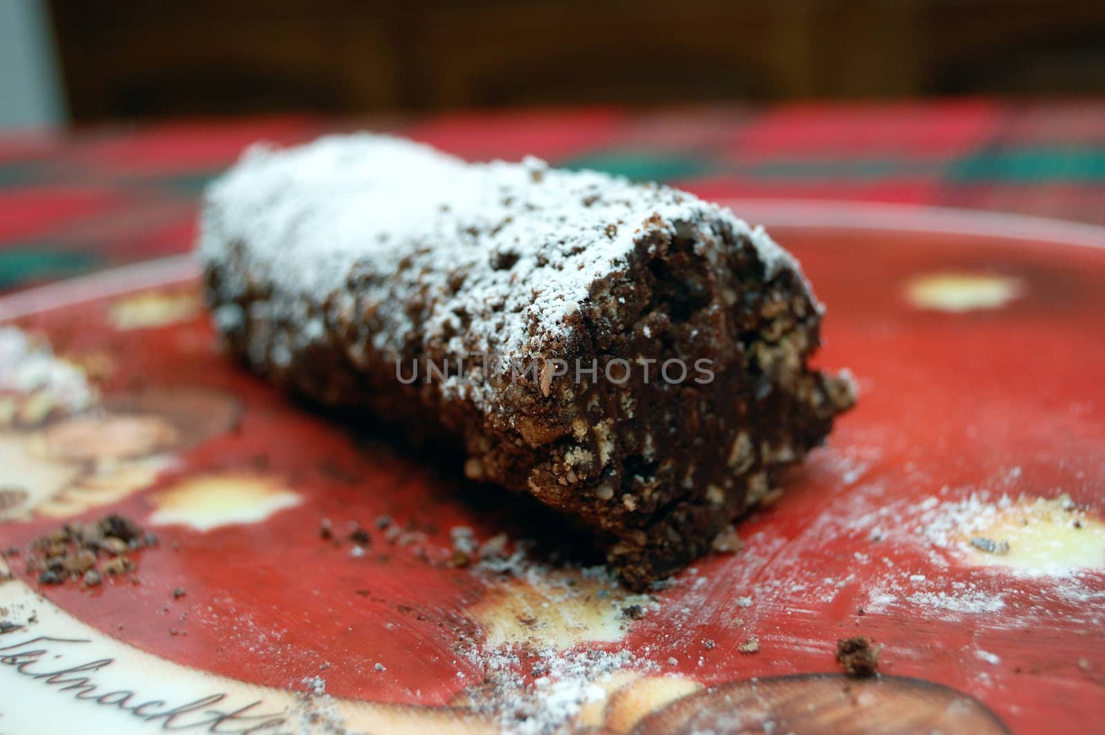 Piece of chocolate salami on a christmans plat.
