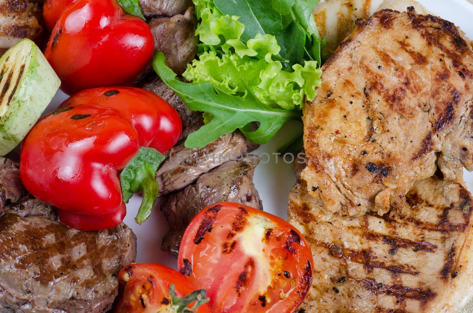 BBQ meat with vegetables and greens closeup