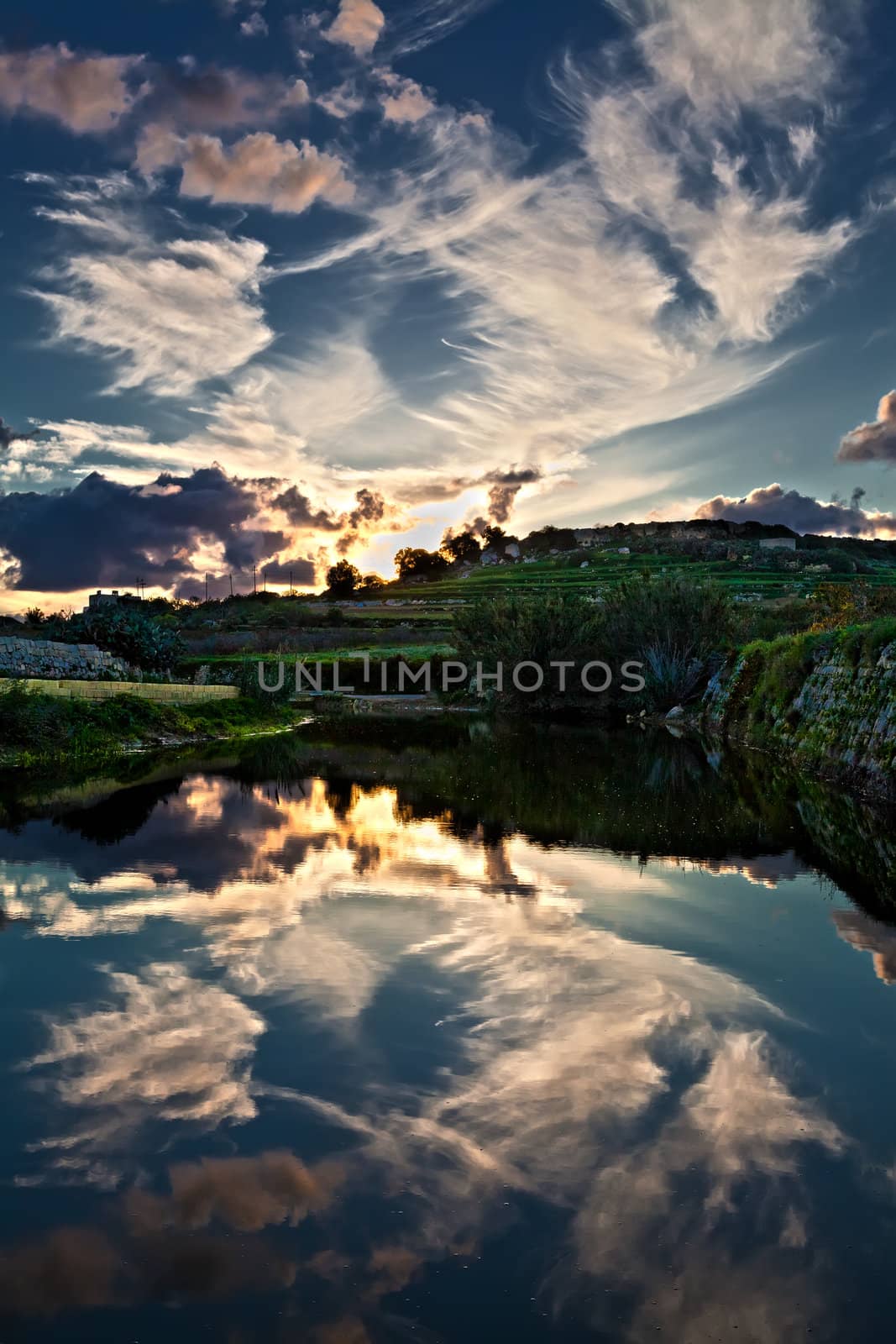 The beauty of the late evening sky as reflected in the calm waters at Chadwick Lakes in Malta
