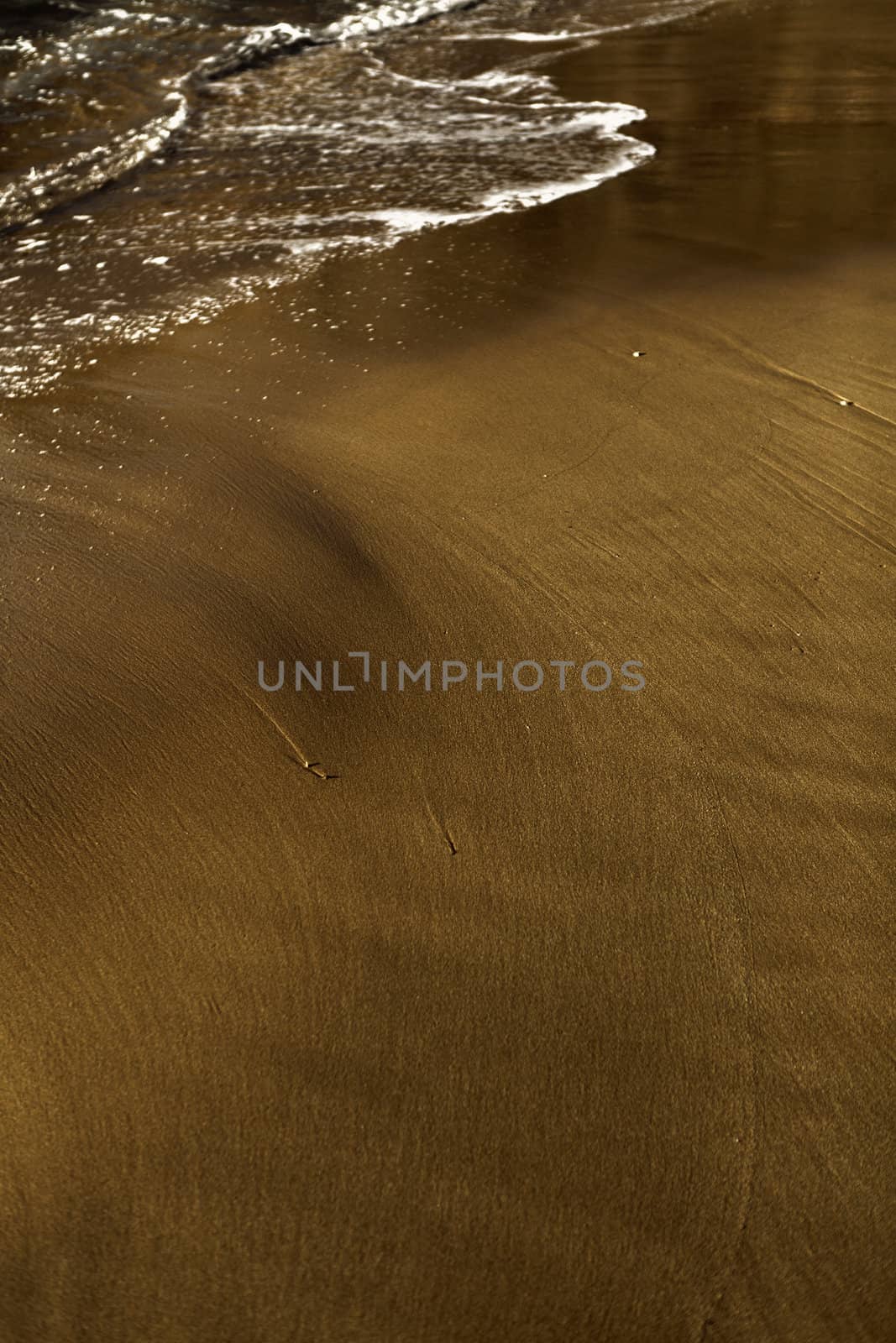 The ebb of the waves creating beautiful patterns on a sand bank