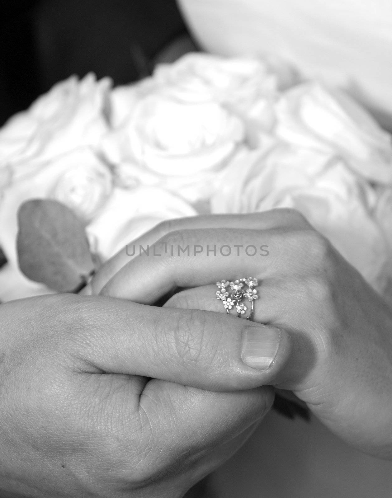 Detail of bride and groom's hands showing wedding band