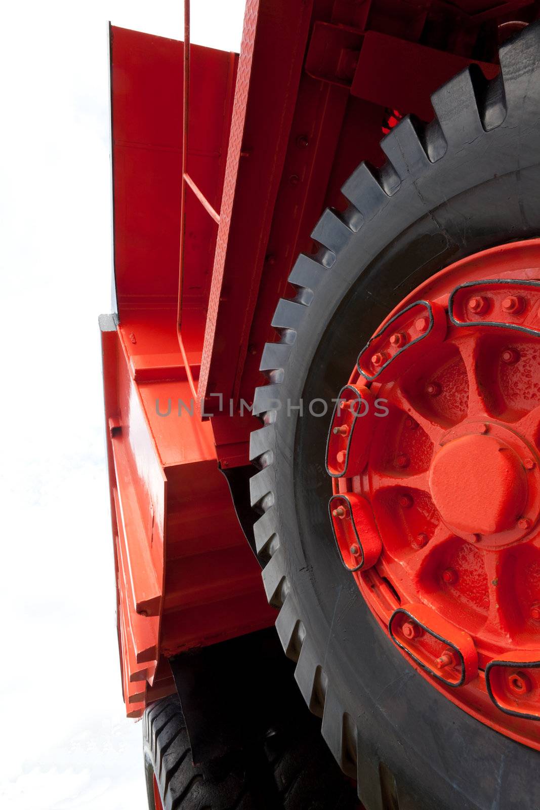 Wheels, rims and tires, and dump bucket of vinatge giant mining truck. Extreme perspective.