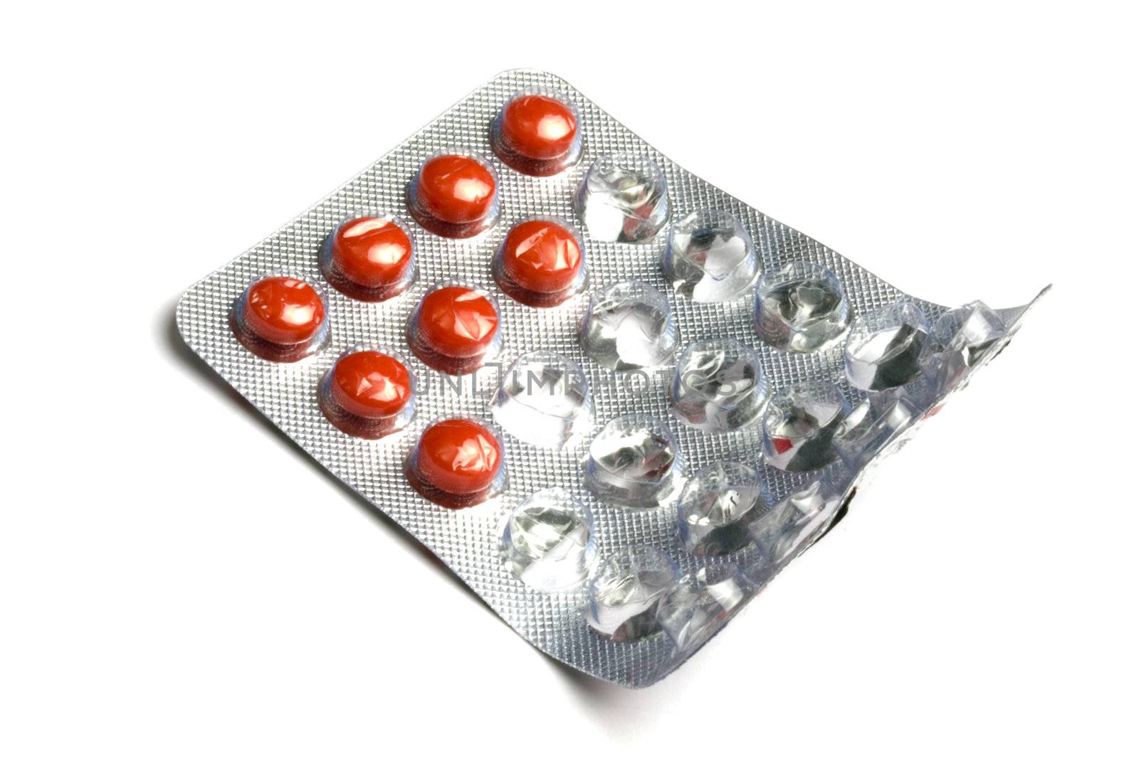 Red pills packed in blister isolated on white background 
