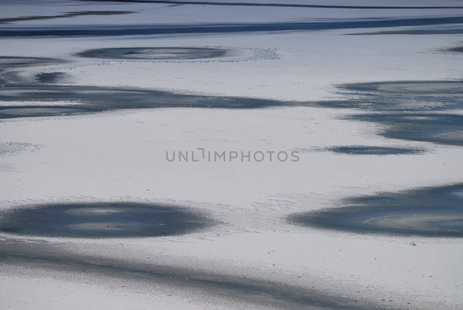 Winter background. Small frozen river with snow and ice