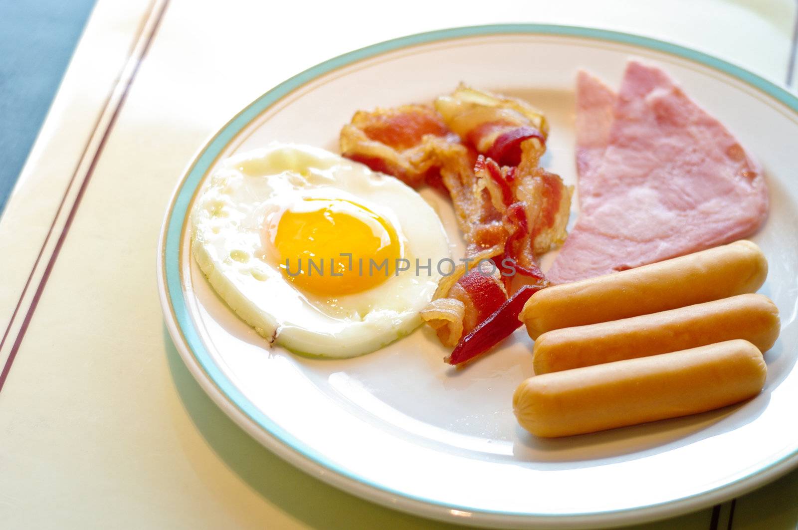Breakfast, fried egg and sausage in white dish