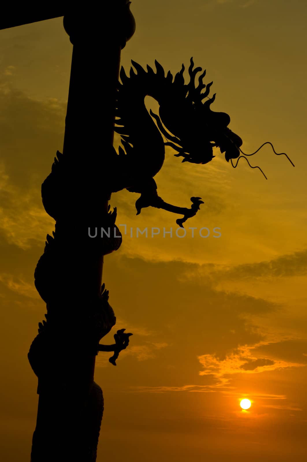 Dragon statue silhouette with sunset sky background