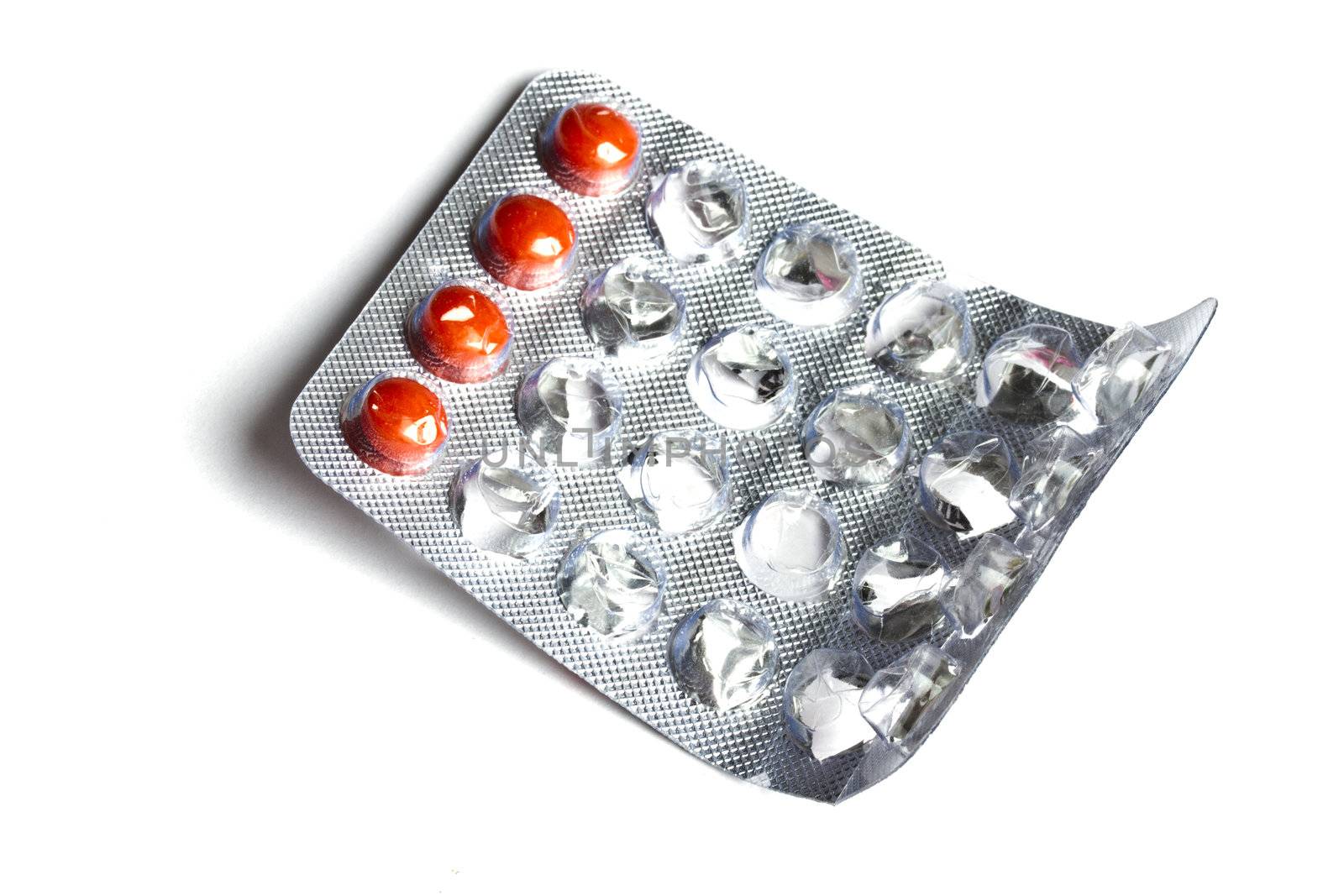 some red pills isolated on white background 
