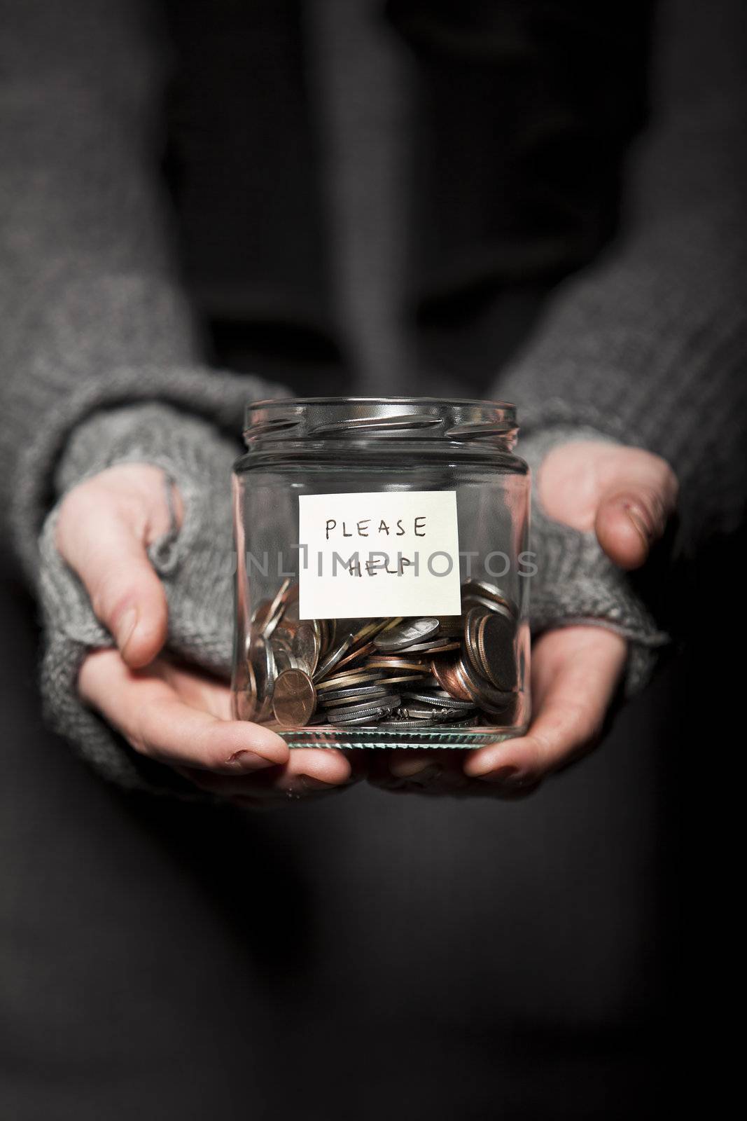 Close up of a Beggars hands and jar of coins