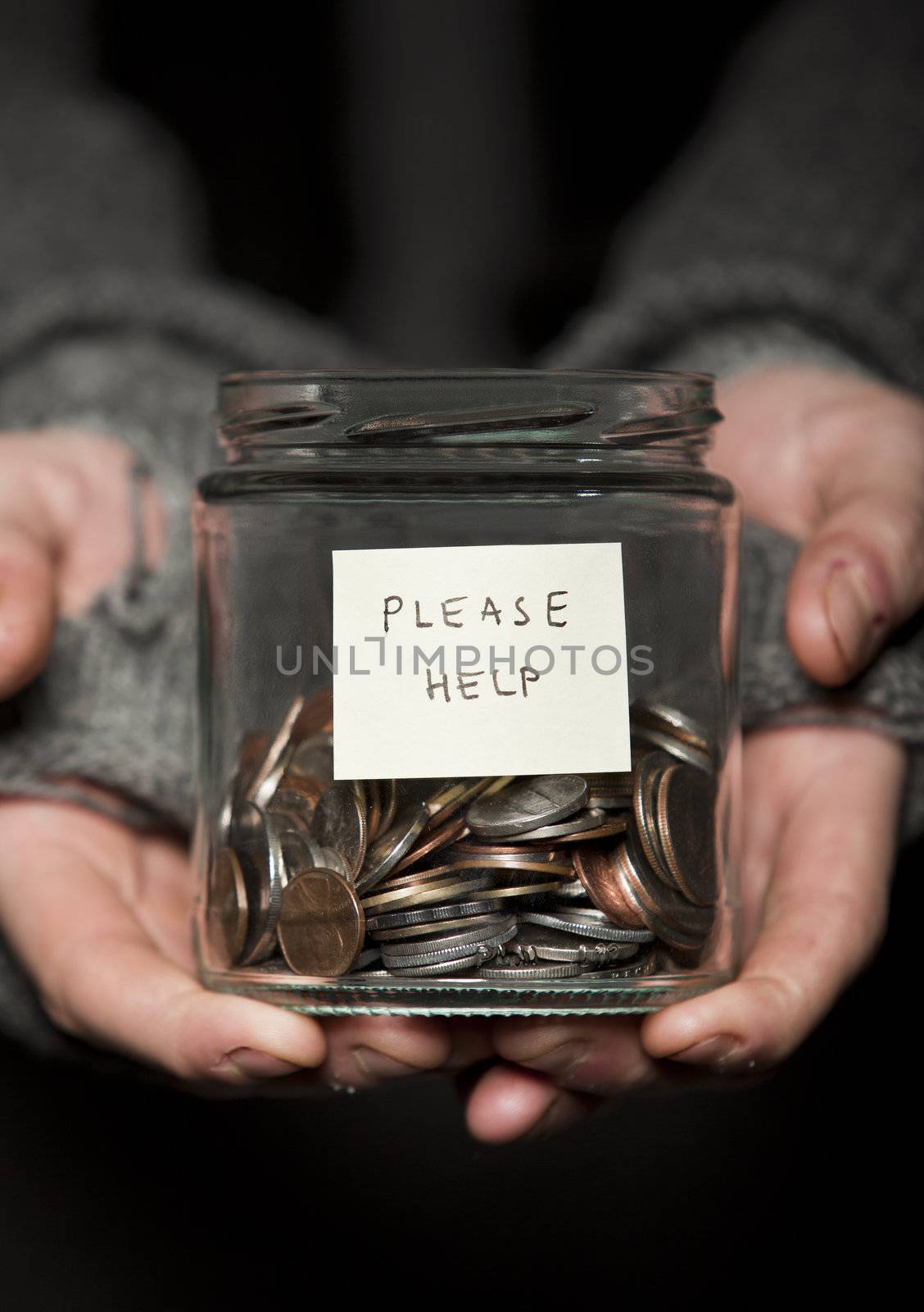 Close up of a Beggars hands and jar of coins