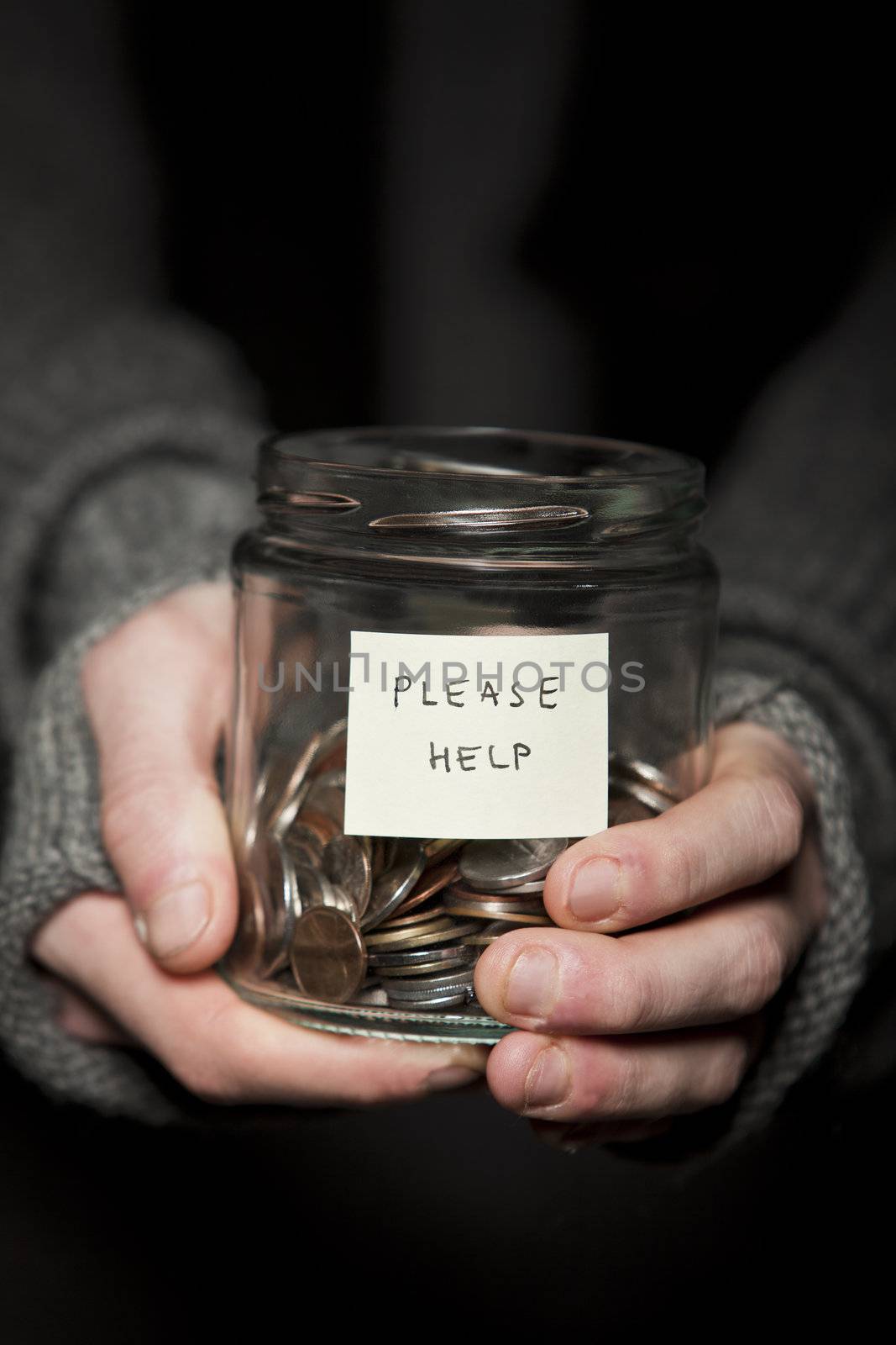 Close up of a Beggars hands and jar of coins
