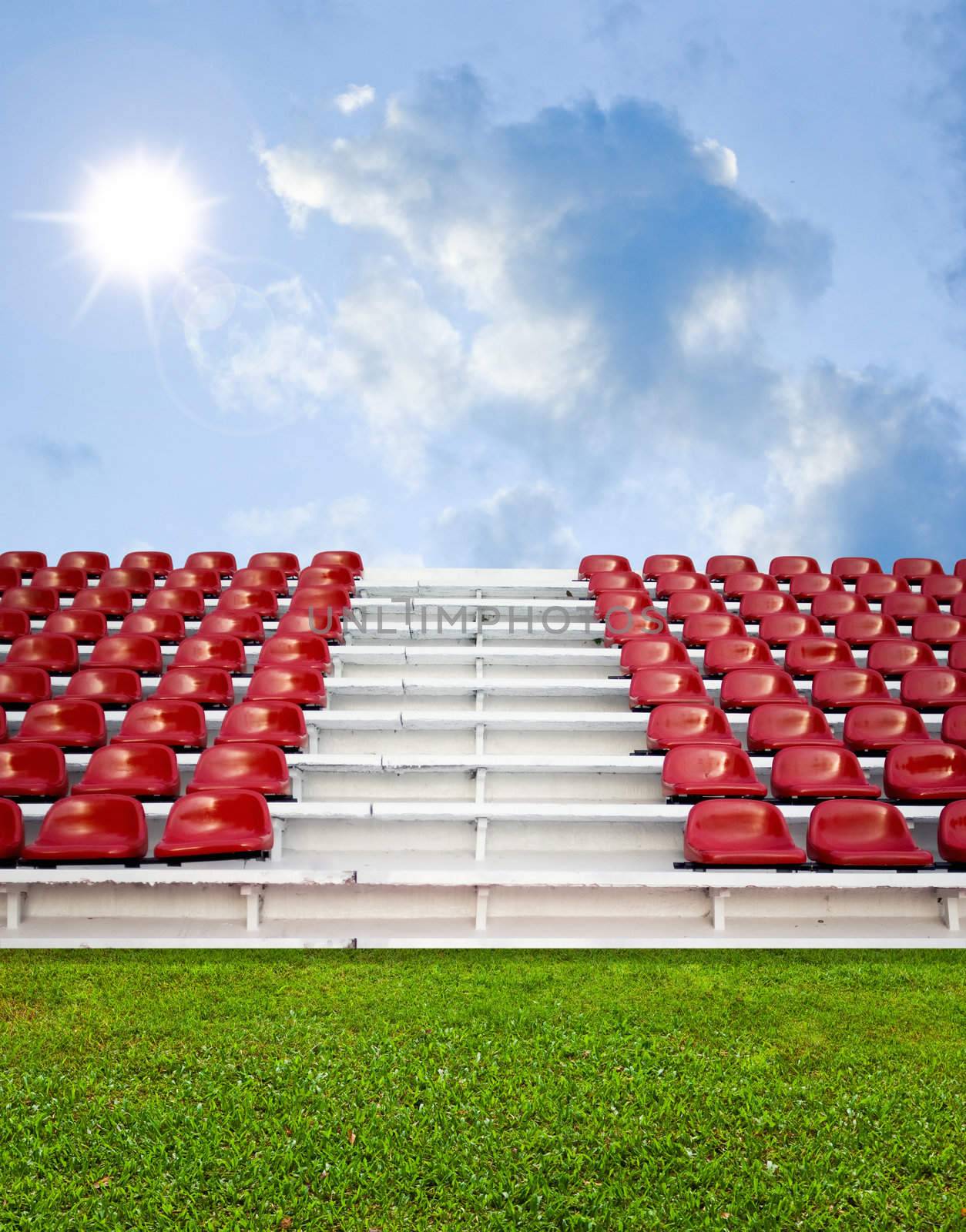 Red bleachers with green field and sky background by pixbox77