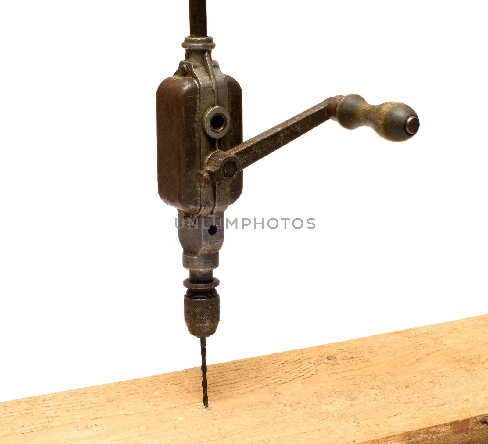 Old hand brace drill the board on a white background.