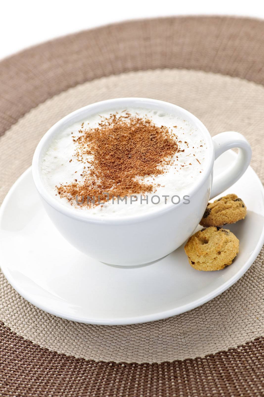 Cappuccino or latte coffee in cup with frothed milk and cookies