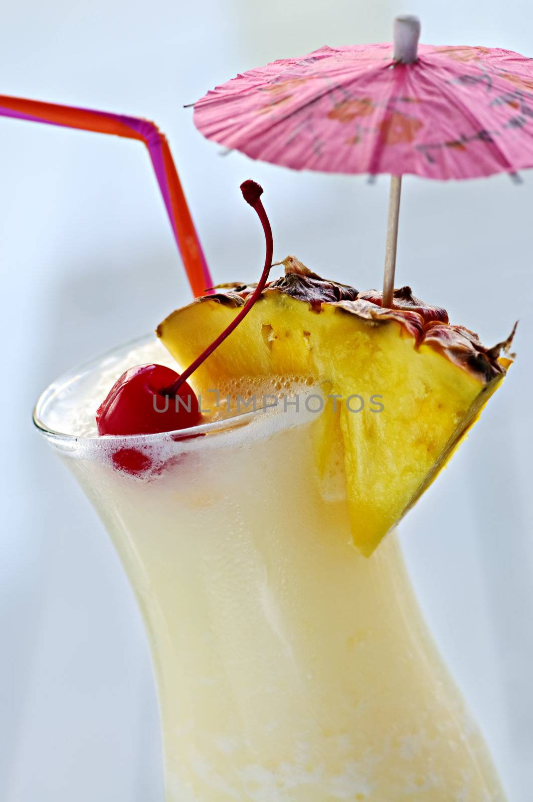 Pina colada drink in hurricane cocktail glass isolated on white background