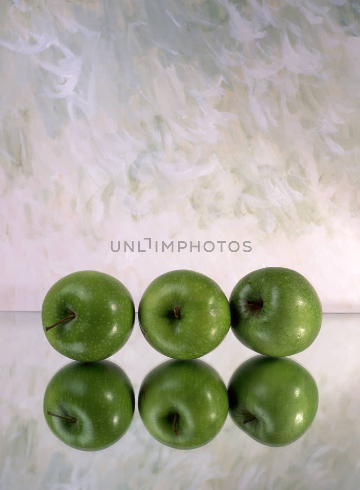Three green apples isolated on mirror 