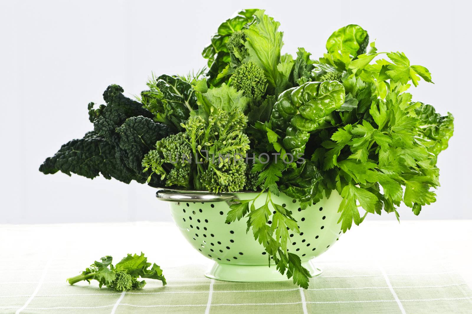 Dark green leafy vegetables in colander by elenathewise