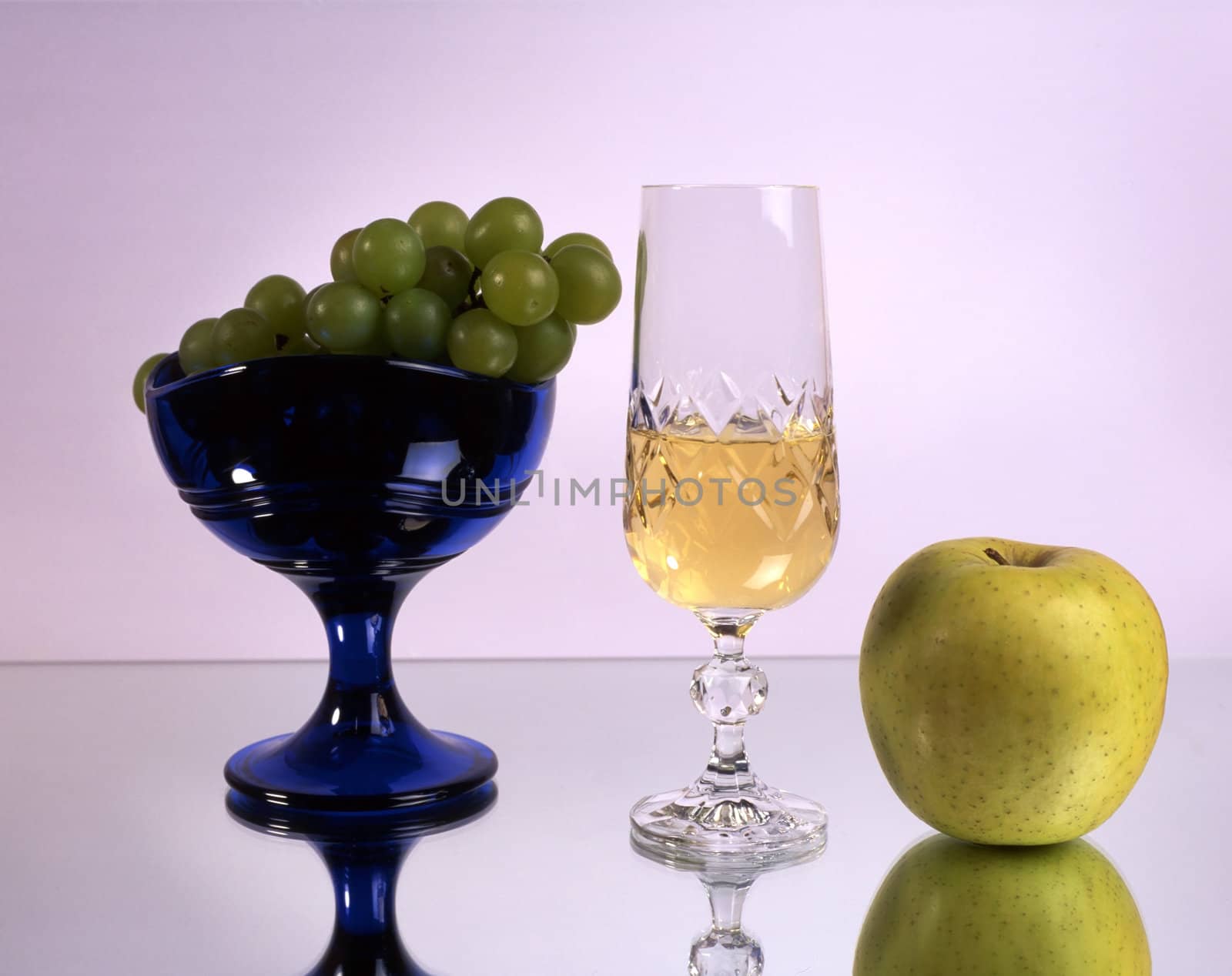 A glass of wine with fruits isolated on mirror