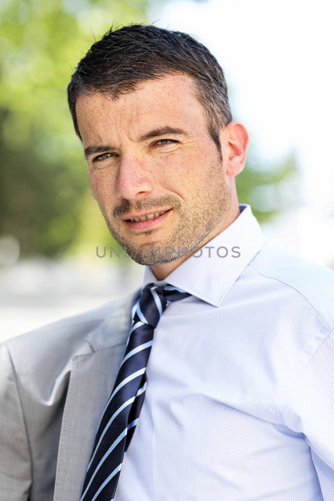 beautiful young businessman with tie outdoor in spring