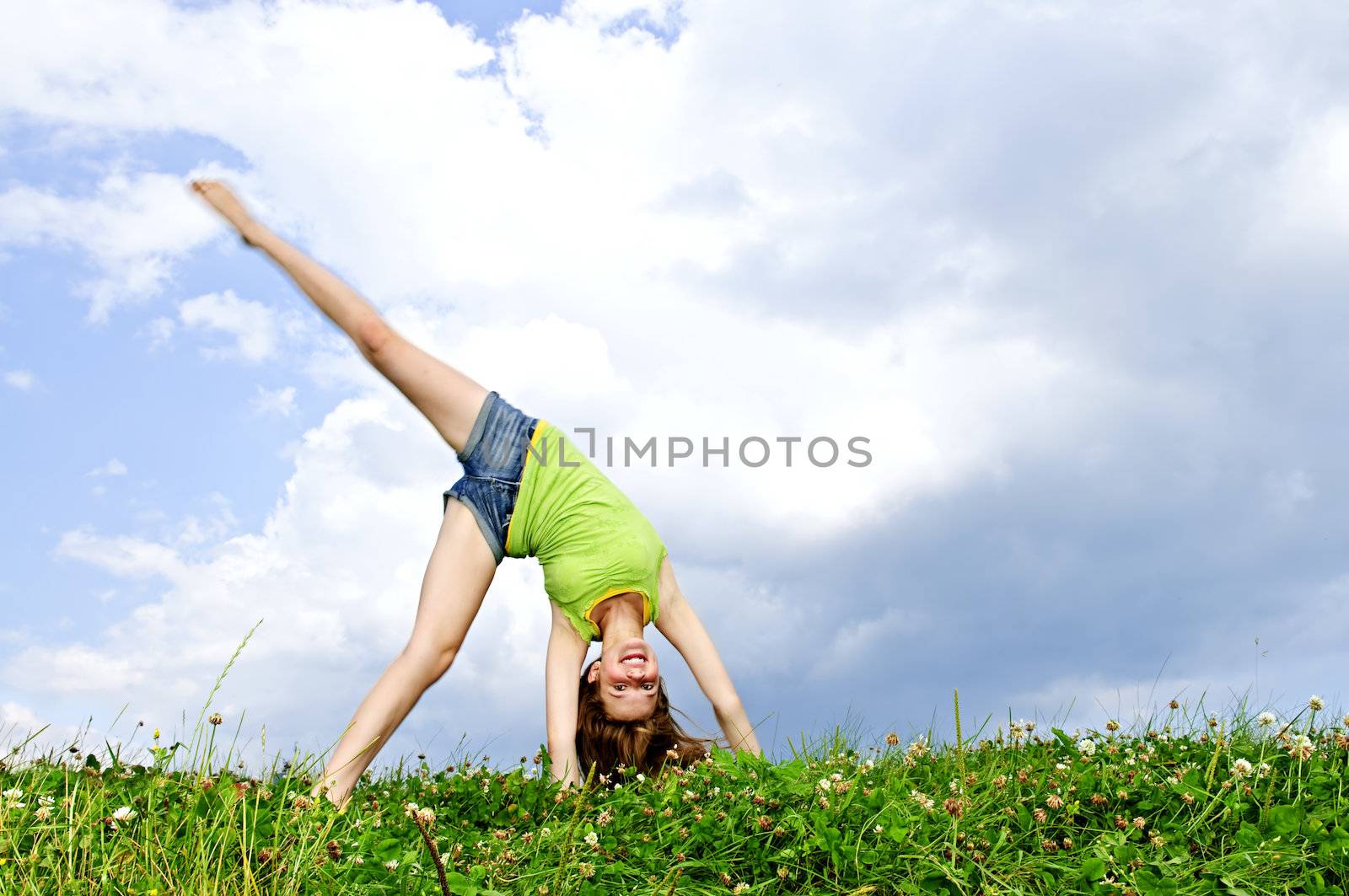 Young girl doing cartwheel by elenathewise