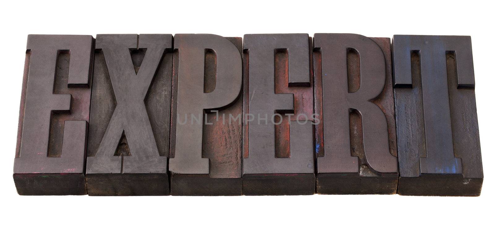 expert word in antique wooden letterpress printing blocks, stained by color inks, isolated on white
