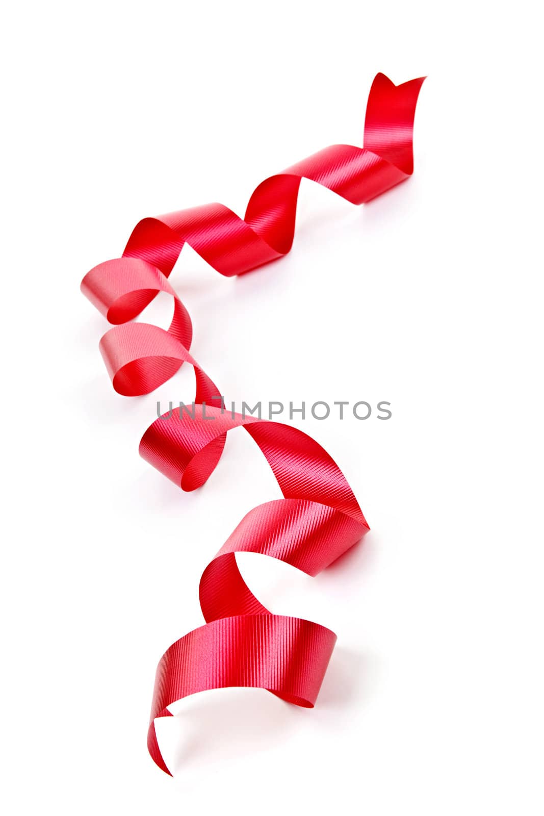 Curled red holiday ribbon strip isolated on white background