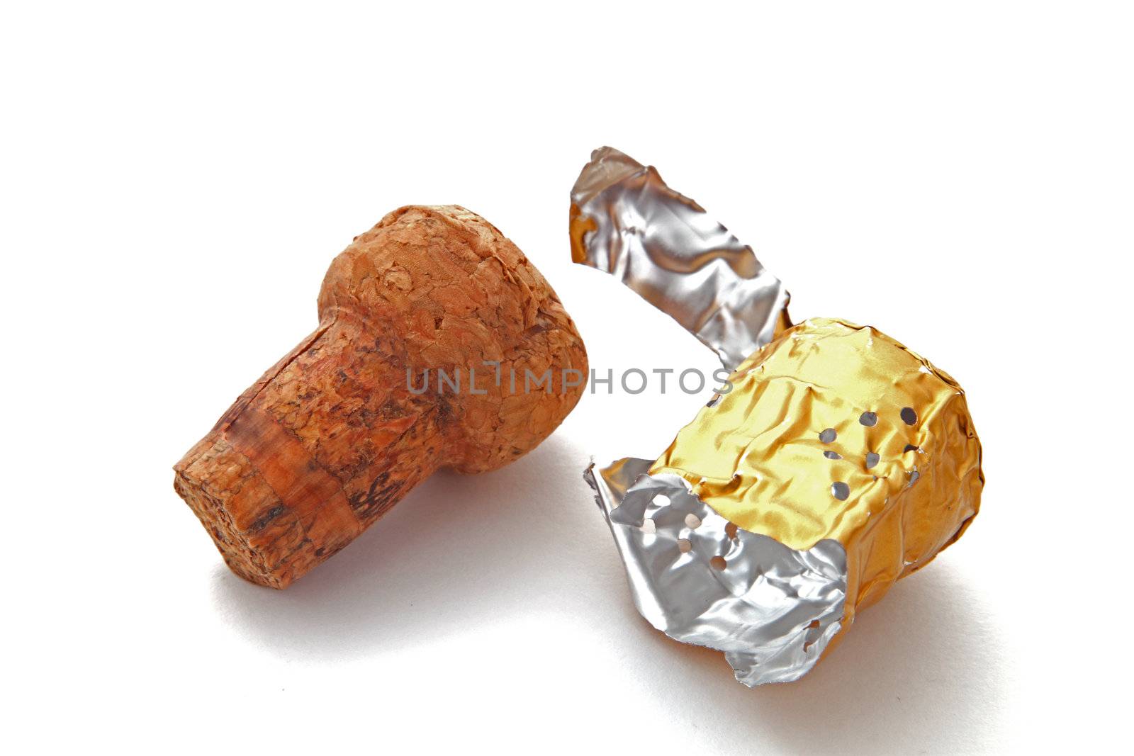 Champagne cork and foil on a plain white background.