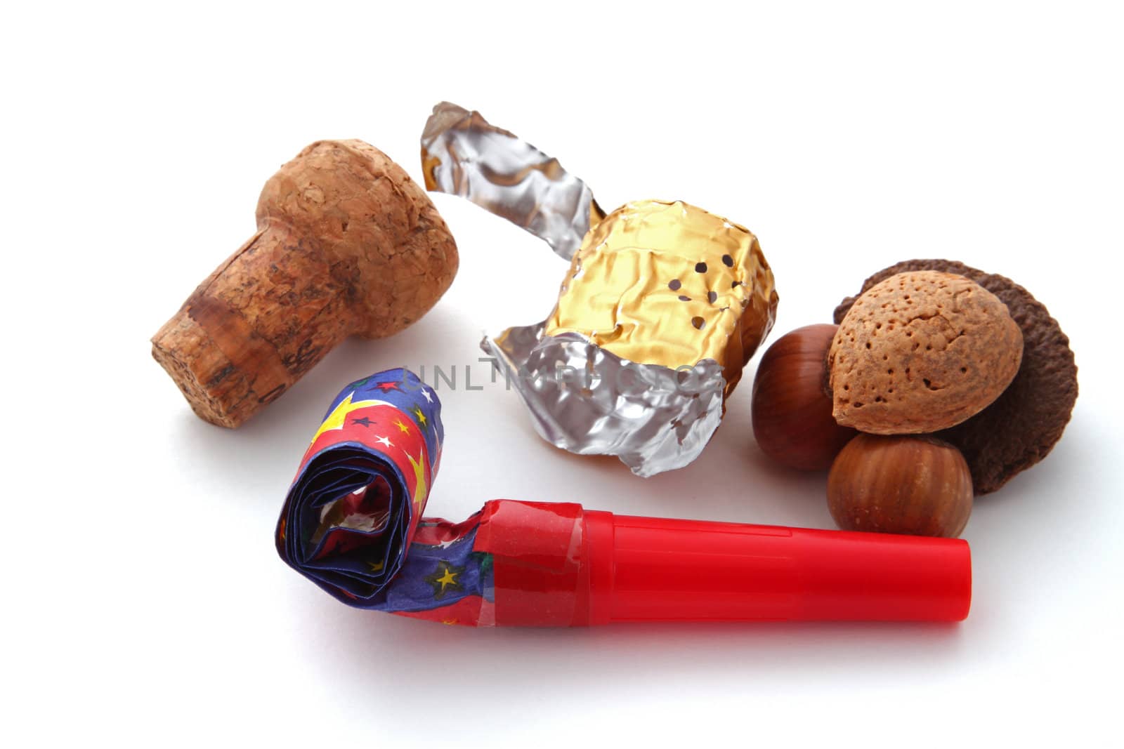 Champagne cork, foil, blower and nuts on a plain white background.