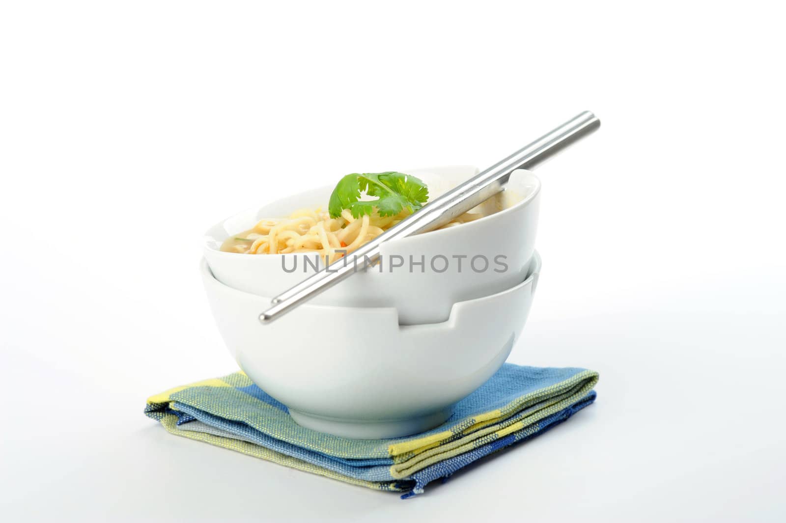 Two bowls of oriental style noodles and broth.