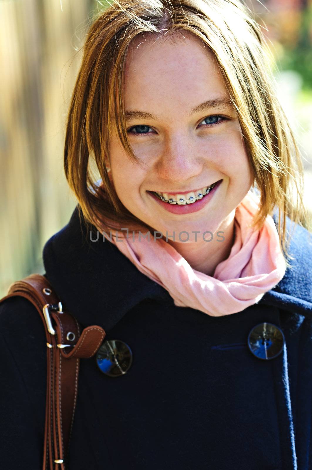 Portrait of teenage girl smiling wearing coat and scarf