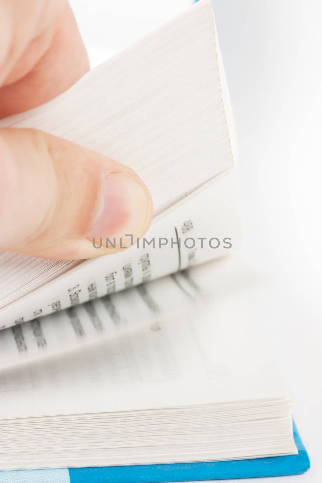 Male finger turning over the pages of thick book