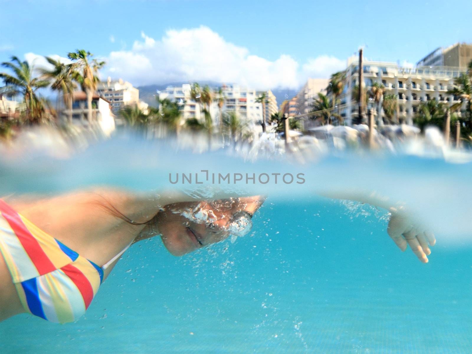 Swimmer. Woman swimming crawl in pool outside on tropical holiday resort. 