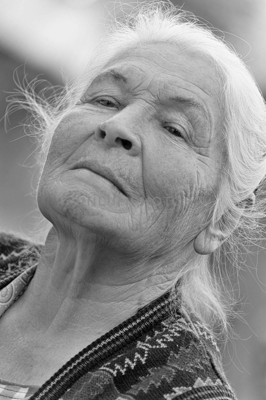 Portrait of the elderly woman. Monochrome. A photo on outdoors