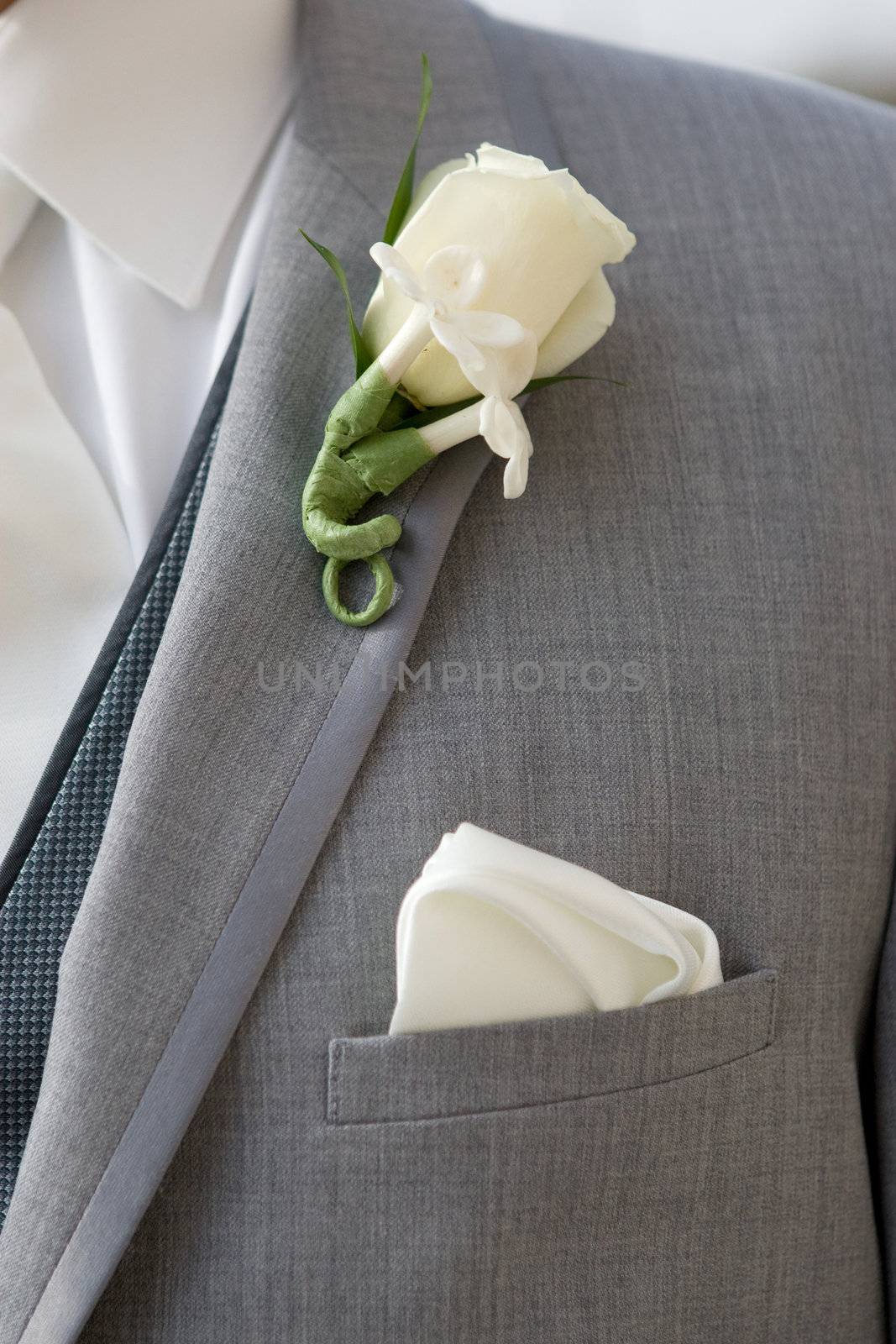 Groom in grey suit wearing a boutonniere by svenler