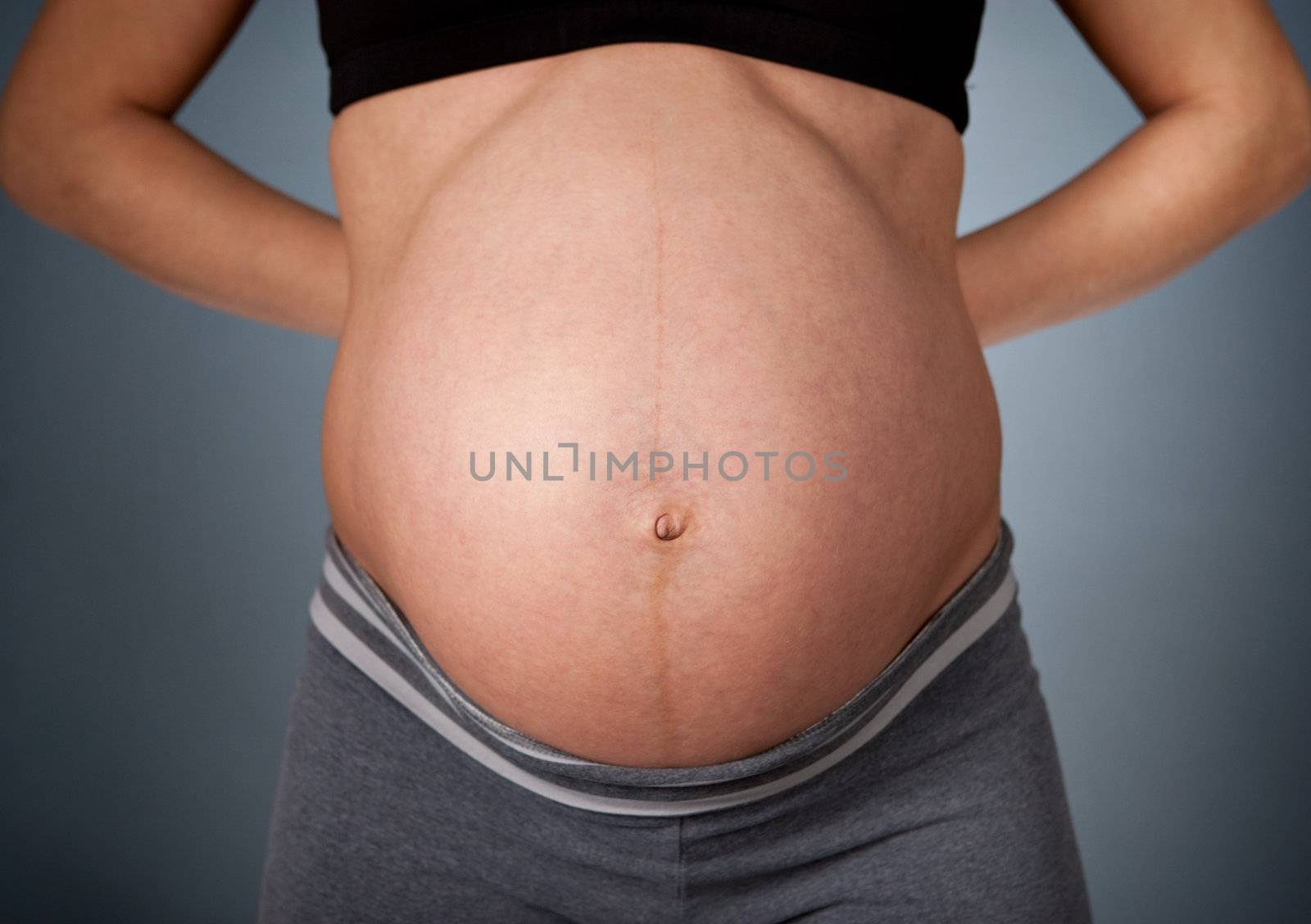 Young pregnant woman holding her back